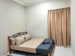 a small bedroom with a bed and a curtain at GRANDE MAISON 4 Near AFamosa Waterpark Fully Air Conditioned in Kampong Pulau Sebang