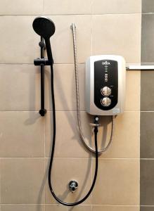 a shower head and a soap dispenser on a wall at GRANDE MAISON 4 Near AFamosa Waterpark Fully Air Conditioned in Kampong Pulau Sebang