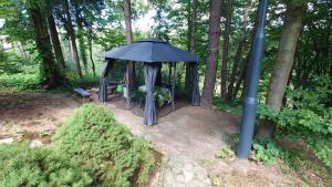 a gazebo with a bench and an umbrella at Rysiówka in Krempna