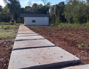 a concrete path leading to a white building at Rincon Amanay in Puerto Esperanza