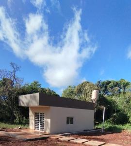 a small white building with trees in the background at Rincon Amanay in Puerto Esperanza