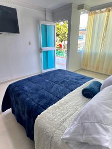 a bedroom with a large bed with a blue blanket at Casa Encanto Para Grupos y Familias in Bucaramanga