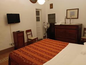 a bedroom with a bed and a dresser and a television at Appartamenti Arena in Macerata