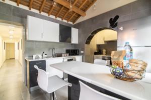 a kitchen with a white counter and white chairs at Atlantic Seaview Window in Feteiras