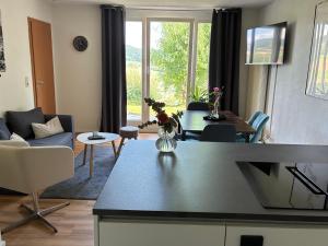 a kitchen and living room with a table and chairs at FeWo Silence&View in Weilheim