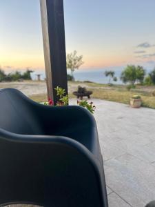 a chair sitting on a porch with a view of the ocean at David in Cefalù