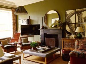 een woonkamer met een open haard en een spiegel bij Elegant Georgian Retreat with Views of Arthurs Seat in Edinburgh