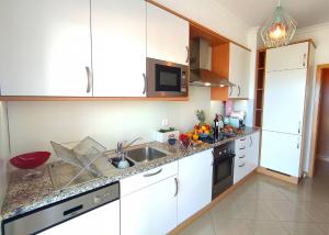 een keuken met witte kasten en een spoelbak bij AlbufeiraOrada II by Be Cherish in Páteo