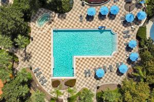 an overhead view of a swimming pool with chairs and umbrellas at Encantada Resort Vacation Townhomes by IDILIQ in Kissimmee