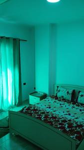 a bedroom with a bed with a blue light at Qetesia Apartment in Shkodër