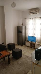 a living room with a television and a couch and a table at Qetesia Apartment in Shkodër