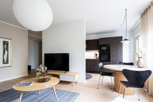 a kitchen and living room with a table and chairs at UPEA keskustan kaksio in Kuopio