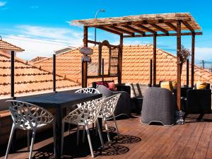 a black table and chairs on a wooden deck at Behappy Lodge & Rooftop in Esmoriz