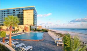 a hotel with a swimming pool next to the beach at Daytona oceanfront two-bedroom suite in Daytona Beach