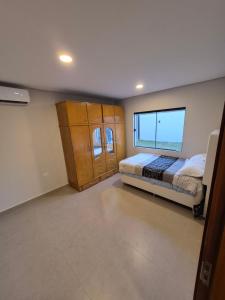 a bedroom with two beds and a large window at Tu casa moderna con Quincho in Asuncion