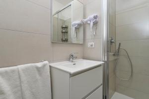 a white bathroom with a sink and a shower at Actus Palace Rooms by Ghor in Rome +7 photos