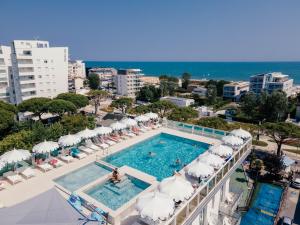 an overhead view of a swimming pool with umbrellas and the ocean at Hotel Colombo in Lido di Jesolo