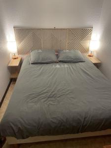 a large bed in a bedroom with two lamps at Appt de montagne Araches in Arâches-la-Frasse