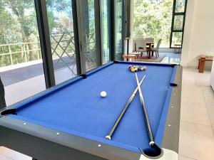 Deco Home The Summit Mesilau at Kundasang في Kampong Kundassan: طاولة بلياردو في غرفة المعيشة مع مسبح