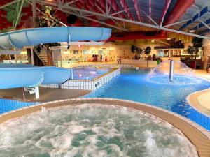 a large indoor swimming pool with a water slide at Vakantiehuis Lochem in Lochem