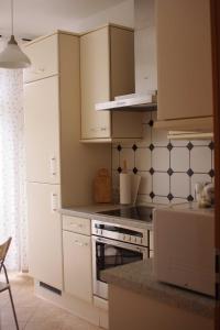 a kitchen with white cabinets and a stove top oven at Ferienwohnung Bülow GM 69131 in Müritz