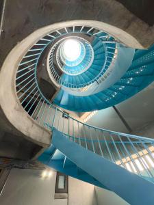 eine Wendeltreppe in einem Gebäude mit blauer Decke in der Unterkunft Hotel Once22 in Sabaneta