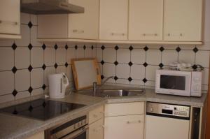a kitchen with a sink and a microwave at Ferienwohnung Bülow GM 69131 in Müritz