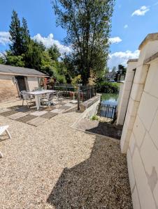 a backyard with a picnic table and a fence at La maison au bord de la riviére in Loches