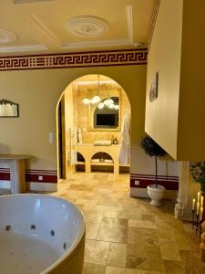 a large bathroom with a tub and a mirror at Roma Antiqua - Suite avec Balnéo - Centre historique in Dinan