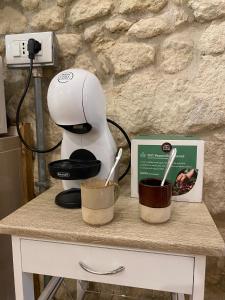 a coffee maker sitting on a table with two cups at Dani's House Holiday in Cagliari