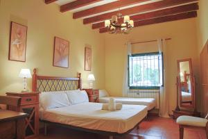 a bedroom with two beds and a chandelier at Casa La Vega in Colmenar de Oreja