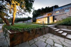 a brick building with stairs and a yard at Casas do Sarela by Upper Luxury Housing in Santiago de Compostela