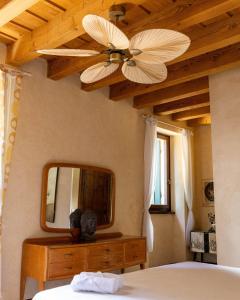 a bedroom with a ceiling fan and a mirror at Corte Pozzol in Rivoli Veronese +28 photos