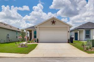 a house with a garage in a residential neighborhood at 12 Mi to San Antonio River Walk Home with Yard! in Elmendorf