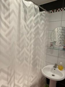 a bathroom with a white shower curtain and a sink at Ventspils Juras in Ventspils +20 photos
