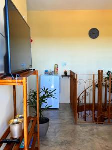 ein Wohnzimmer mit einem TV und einem Kühlschrank in der Unterkunft Casa no Centro Próxima ao Thermas Water Park in Águas de São Pedro + 41 Fotos