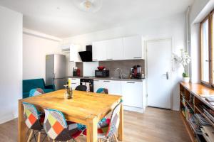 a kitchen and dining room with a wooden table and chairs at Two room apartment - centre historique in Mulhouse +26 photos