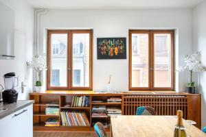 a kitchen with two windows and a table with chairs at Two room apartment - centre historique in Mulhouse