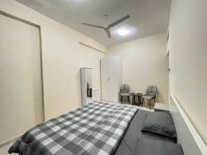 a bedroom with a bed and two chairs in it at Spacious Fully Furnished Master Room in Ajman 