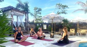 a group of people sitting in a yoga pose at CAPAO Beach Hôtel in Cap d'Agde +47 photos