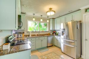 a kitchen with white cabinets and a stainless steel refrigerator at Swim, Fish and Walk to Shore Ormond Beach Home! in Ormond-by-the-Sea