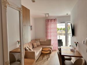 a living room with a couch and a table at Nadmorski Relaks - komfortowy apartament blisko plaży w Sunset Resort in Grzybowo