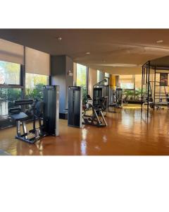 a gym with several treadmills and chairs in a room at Bayfront Suite in Pasay, Manila Near NAIA Terminal, PICC, Star City, MOA and US Embassy - Pet-Friendly, Free Pool, Wi-Fi & Netflix in Manila