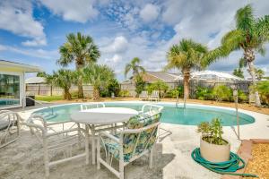 a patio with a table and chairs next to a pool at Swim, Fish and Walk to Shore Ormond Beach Home! in Ormond-by-the-Sea
