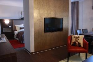 ein Hotelzimmer mit einem TV an der Wand in der Unterkunft Mr.& Mrs. President in Erfurt