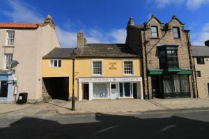 a yellow building on the corner of a street at Centre Of Britain Hotel in Haltwhistle