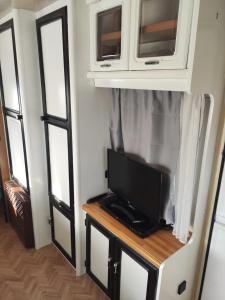 a tv on a table in a room with windows at Caravane avec spa privatif en campagne in Apremont