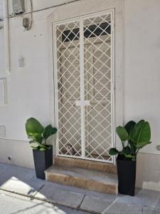 a door with two potted plants in front of it at Dolce Giò A in Mazara del Vallo