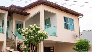 a house with a tree in front of it at Apartamento charmoso 3/4 in Ilhéus