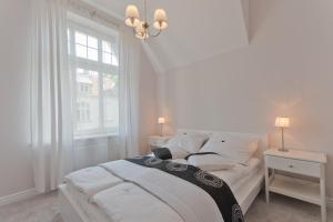 biała sypialnia z łóżkiem i oknem w obiekcie Imperial Apartments - Galeria w mieście Sopot